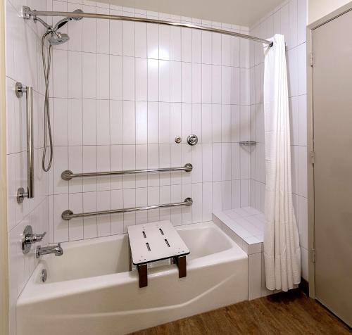 a bathroom with a bath tub with a bench in it at Seacliff Inn Aptos, Tapestry Collection by Hilton in Aptos