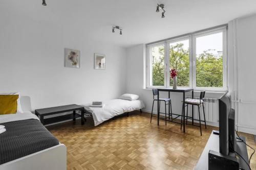 a bedroom with a bed and a desk and a tv at Żuromińska Comfort Studio in Warsaw