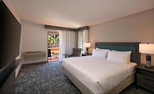 阿普托斯Seacliff Inn Aptos, Tapestry Collection by Hilton的带床和阳台的酒店房间