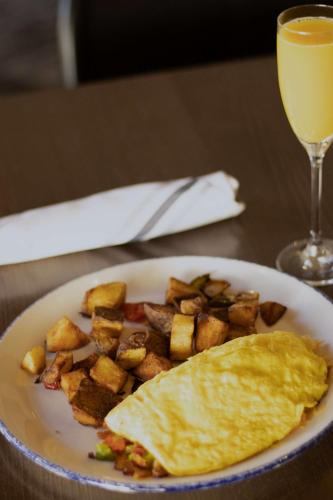a plate of breakfast food with an omelet and a drink at Seacliff Inn Aptos, Tapestry Collection by Hilton in Aptos