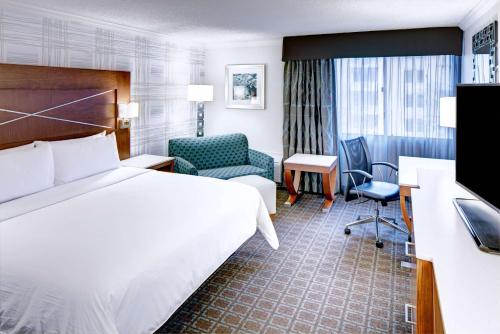 um quarto de hotel com uma cama e uma cadeira em DoubleTree by Hilton Madison Downtown em Madison