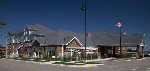 a large building with an american flag in front of it at Homewood Suites by Hilton Madison West in Madison