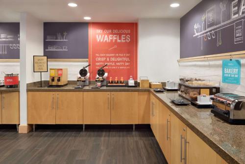 a kitchen with wooden cabinets and a counter top at Hampton Inn & Suites Madison - West in Madison