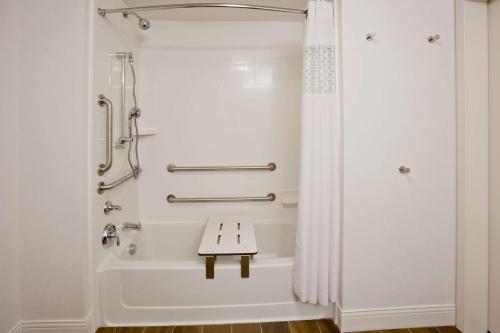 a bathroom with a shower with a bench in it at Hampton Inn Minneapolis Bloomington West in Bloomington