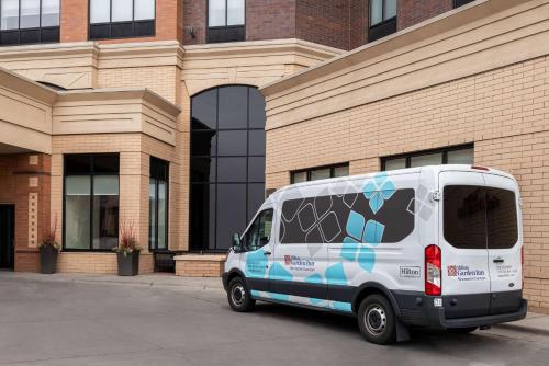 a white van parked in front of a building at Hilton Garden Inn Minneapolis Downtown in Minneapolis