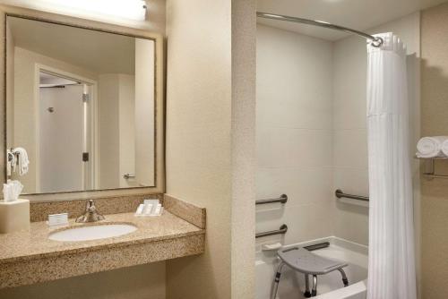 a bathroom with a sink and a toilet and a mirror at Hilton Garden Inn Minneapolis Downtown in Minneapolis