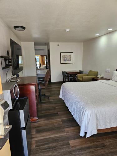 Habitación de hotel con cama y sala de estar. en Rodeway Inn en Tucumcari