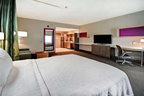 a hotel room with a bed and a desk and a television at Home2 Suites By Hilton Eagan Minneapolis in Eagan