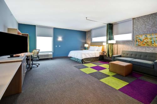 a hotel room with a bed and a flat screen tv at Home2 Suites By Hilton Eagan Minneapolis in Eagan