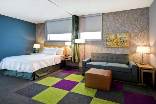 une chambre d'hôtel avec un lit et un canapé dans l'établissement Home2 Suites By Hilton Eagan Minneapolis, à Eagan