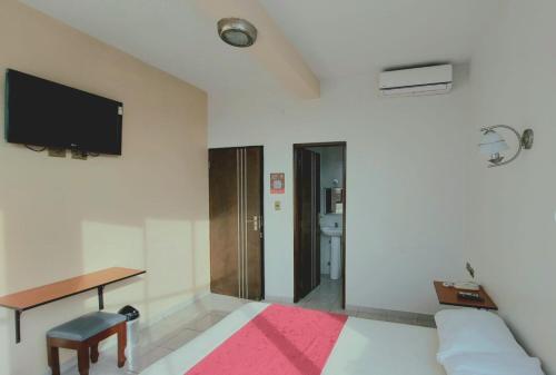 a bedroom with a bed and a desk and a tv at Hotel Plaza Center in Santa Cruz de la Sierra