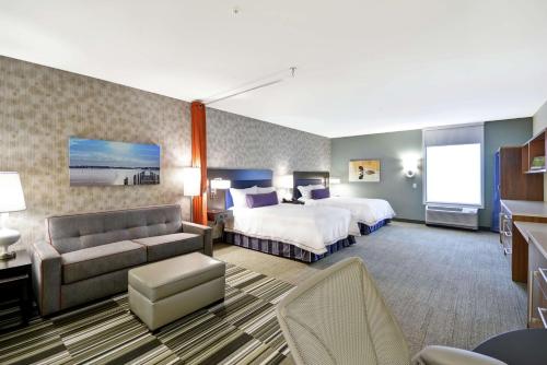 a hotel room with two beds and a couch at Home2 Suites By Hilton Minneapolis-Eden Prairie in Minnetonka