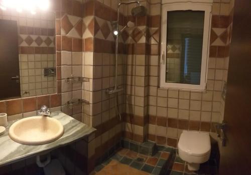 a bathroom with a sink and a toilet at Calma Luxury House in Marmari