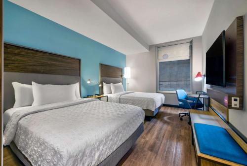 ミネアポリスにあるTru By Hilton Minneapolis, Mnのベッド2台、薄型テレビが備わるホテルルームです。