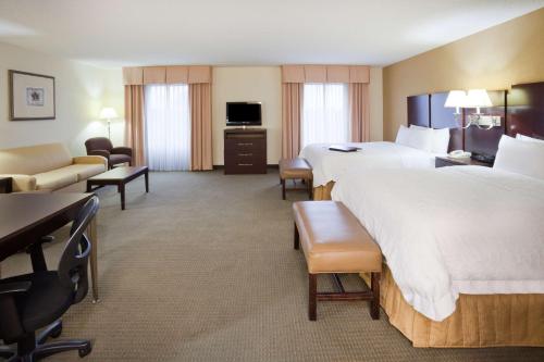 una grande camera d'albergo con due letti e un divano di Hampton Inn & Suites Lino Lakes a Lino Lakes