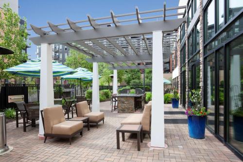 a patio with chairs and tables and umbrellas at Homewood Suites by Hilton Minneapolis - Saint Louis Park at West End in Saint Louis Park