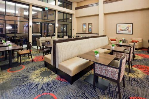 a restaurant with tables and chairs and a couch at Homewood Suites by Hilton Minneapolis - Saint Louis Park at West End in Saint Louis Park