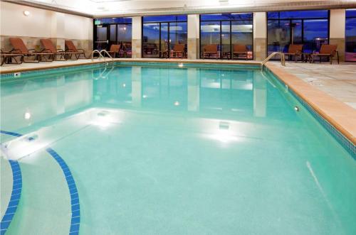a large swimming pool with blue water in a building at Homewood Suites by Hilton Minneapolis - Saint Louis Park at West End in Saint Louis Park