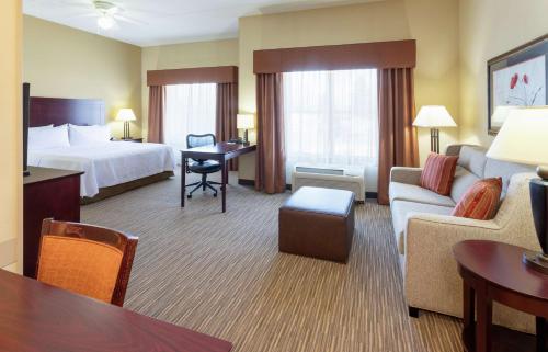 a hotel room with a bed and a living room at Homewood Suites by Hilton Minneapolis - Saint Louis Park at West End in Saint Louis Park