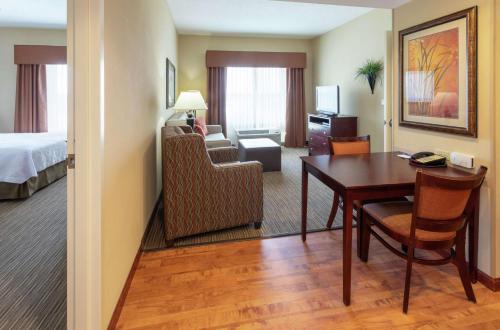 a hotel room with a desk and a bedroom at Homewood Suites by Hilton Minneapolis - Saint Louis Park at West End in Saint Louis Park