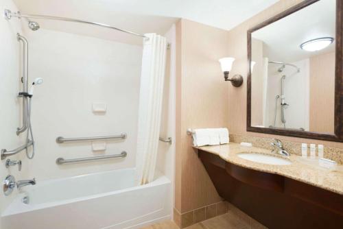 a bathroom with a tub and a sink and a shower at Homewood Suites by Hilton Minneapolis - Saint Louis Park at West End in Saint Louis Park