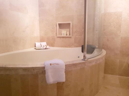 a bathroom with a bath tub with a towel on it at Antara Hotel & Suites - Miraflores in Lima