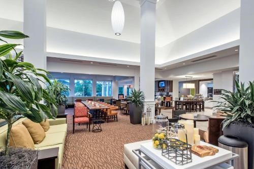 a lobby of a hotel with tables and chairs at Hilton Garden Inn Minneapolis Airport Mall of America in Bloomington