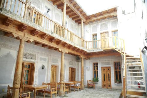 a large room with wooden floors and lots of windows at Komil Bukhara Boutique Hotel in Bukhara