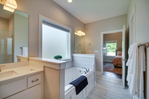 a bathroom with a tub and a sink and a mirror at Fayetteville Vacation Rental with Deck and Shared Pool in Fayetteville