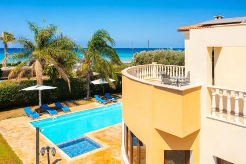 a view of a pool and the ocean from a building at Villa Tsikkos Ena in Argaka