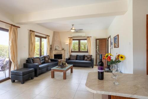 a living room with two couches and a fireplace at Villa Tsikkos Ena in Argaka