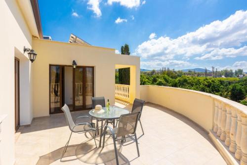a patio with a table and chairs on a balcony at Villa Tsikkos Ena in Argaka