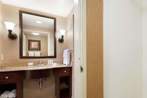 ein Bad mit einem Waschbecken und einem Spiegel in der Unterkunft Homewood Suites New Brighton in Roseville