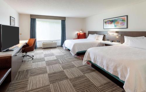 Habitación de hotel con 2 camas y TV de pantalla plana. en Hilton Garden Inn Minneapolis Saint Paul-Shoreview, en Shoreview