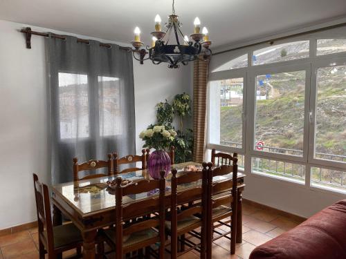 Alojamiento Cerro Socorro في كوينكا: غرفة طعام مع طاولة وكراسي ونوافذ