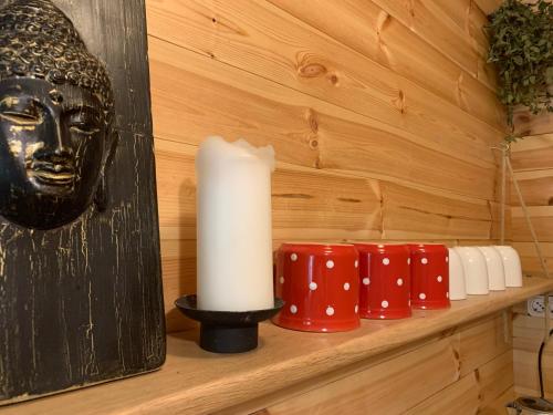 eine Kerze auf einem Regal mit roten und weißen Kerzen in der Unterkunft Gong Faház - Eger in Eger