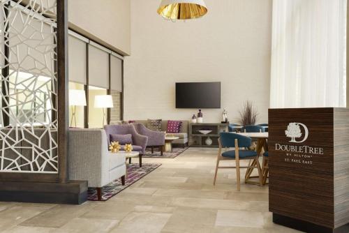 a hotel lobby with a waiting area with chairs and a table at DoubleTree by Hilton St. Paul, MN in Saint Paul