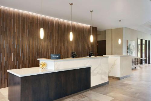 a lobby with a reception counter and pendant lights at DoubleTree by Hilton St. Paul, MN in Saint Paul