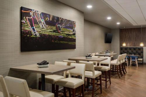 a restaurant with tables and chairs and a painting on the wall at DoubleTree by Hilton St. Paul, MN in Saint Paul
