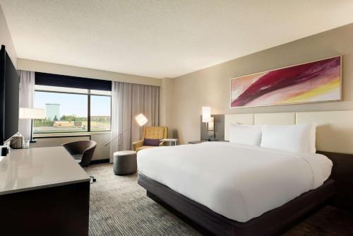 a hotel room with a large white bed and a desk at DoubleTree by Hilton St. Paul, MN in Saint Paul