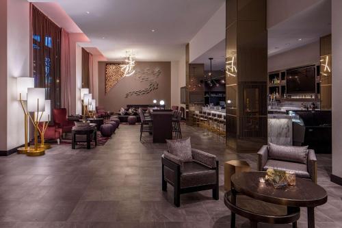 a lobby with chairs and tables and a bar at Embassy Suites By Hilton Minneapolis Downtown Hotel in Minneapolis