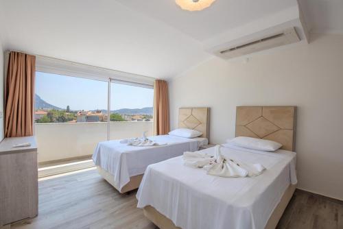 two beds in a room with a large window at Orka World Villa 2 in Oludeniz