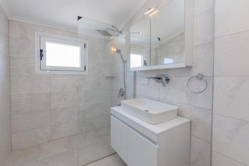 a white bathroom with a toilet and a window at Orka World Villa 2 in Oludeniz