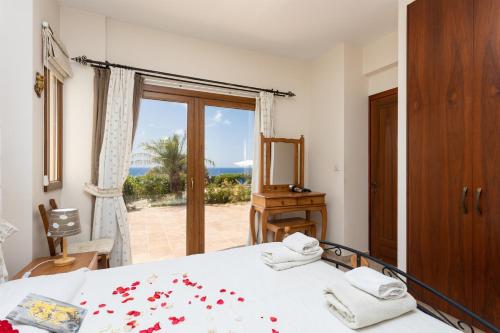 Schlafzimmer mit einem Bett und Meerblick in der Unterkunft Villa Erato in Nea Dimmata