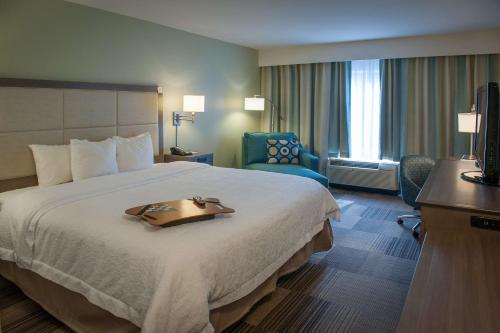a hotel room with a large bed with a tray on it at Hampton Inn & Suites New Orleans/Elmwood in Harahan