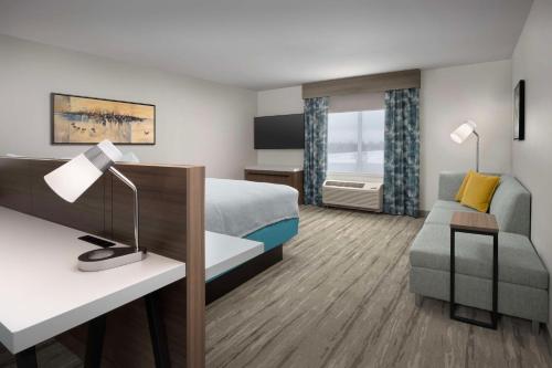 a hotel room with a bed and a desk at Hilton Garden Inn Florence Cincinnati Airport South in Florence