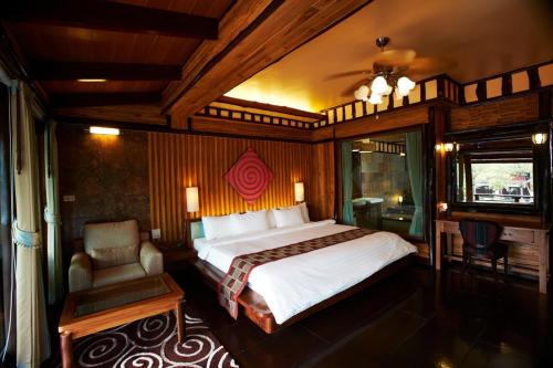 a bedroom with a large bed and a chair at Parama Koh Chang in Ko Chang