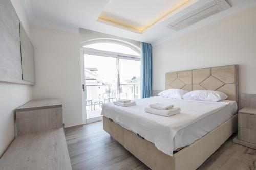 a bedroom with a large bed and a large window at Orka World Villa 1 in Oludeniz