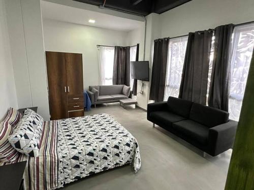 - une chambre avec un lit, un canapé et une chaise dans l'établissement Asombroso Apto 302 Para Grupos en El Poblado, à Medellín