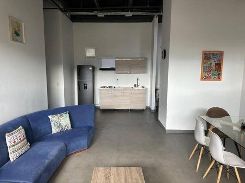 Il comprend un salon avec un canapé bleu et une cuisine. dans l'établissement Asombroso Apto 302 Para Grupos en El Poblado, à Medellín